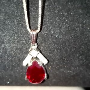 Sterling silver necklace with clear and red crystals. 9" chain and 3/4" pendant.